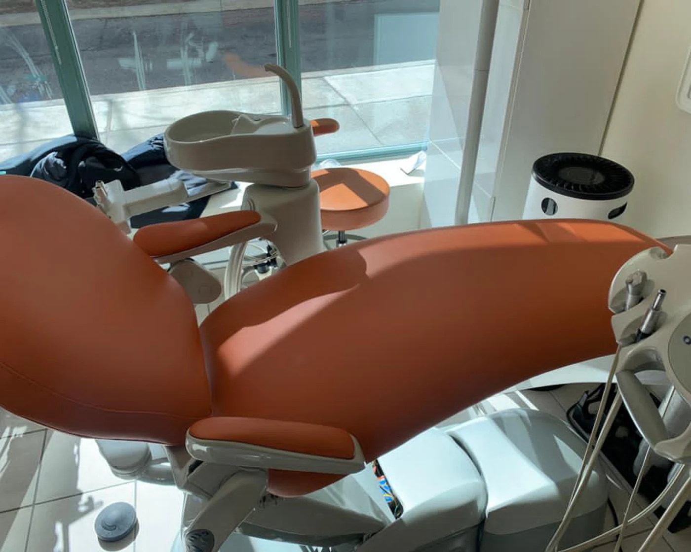 Dental patient chair with renewed orange upholstery after restoration